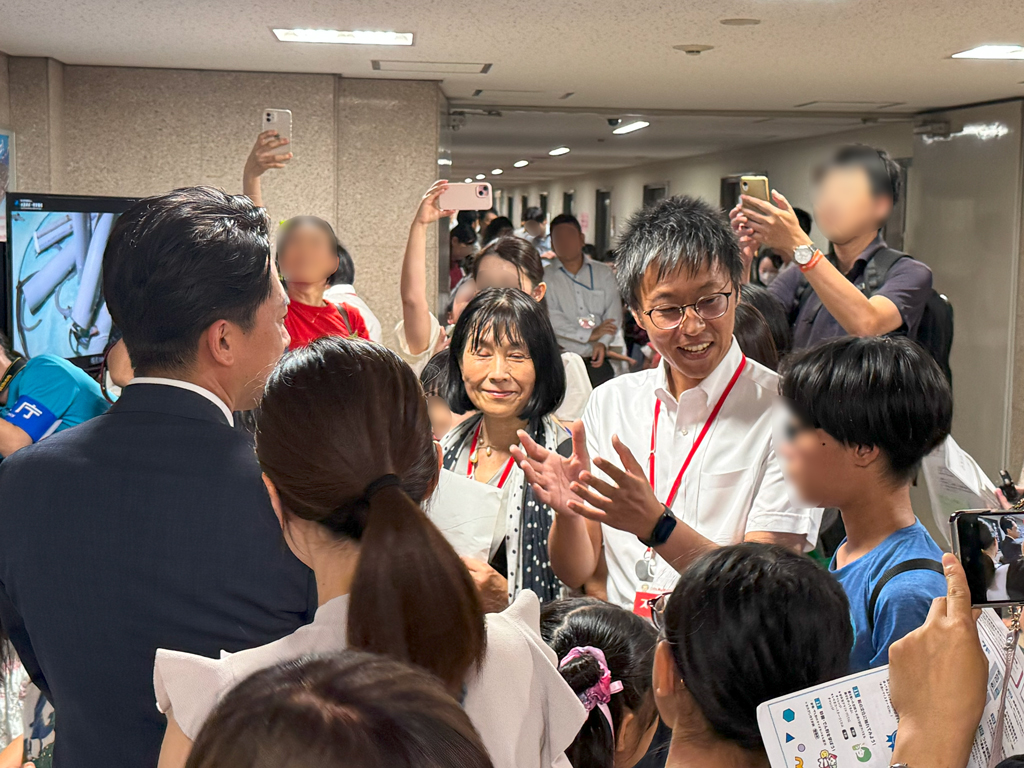 見学に来たこどもを交えてウナギ養殖技術について説明する機構理事及び研究者