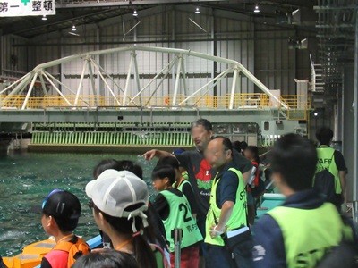海洋工学総合実験棟で、水槽に起こした波に見入る児童の様子がわかる画像